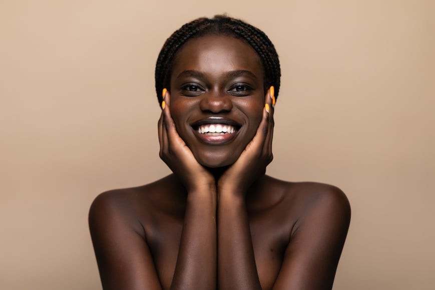 Young african girl with perfect skin on beige background. Beauty Skin care concept